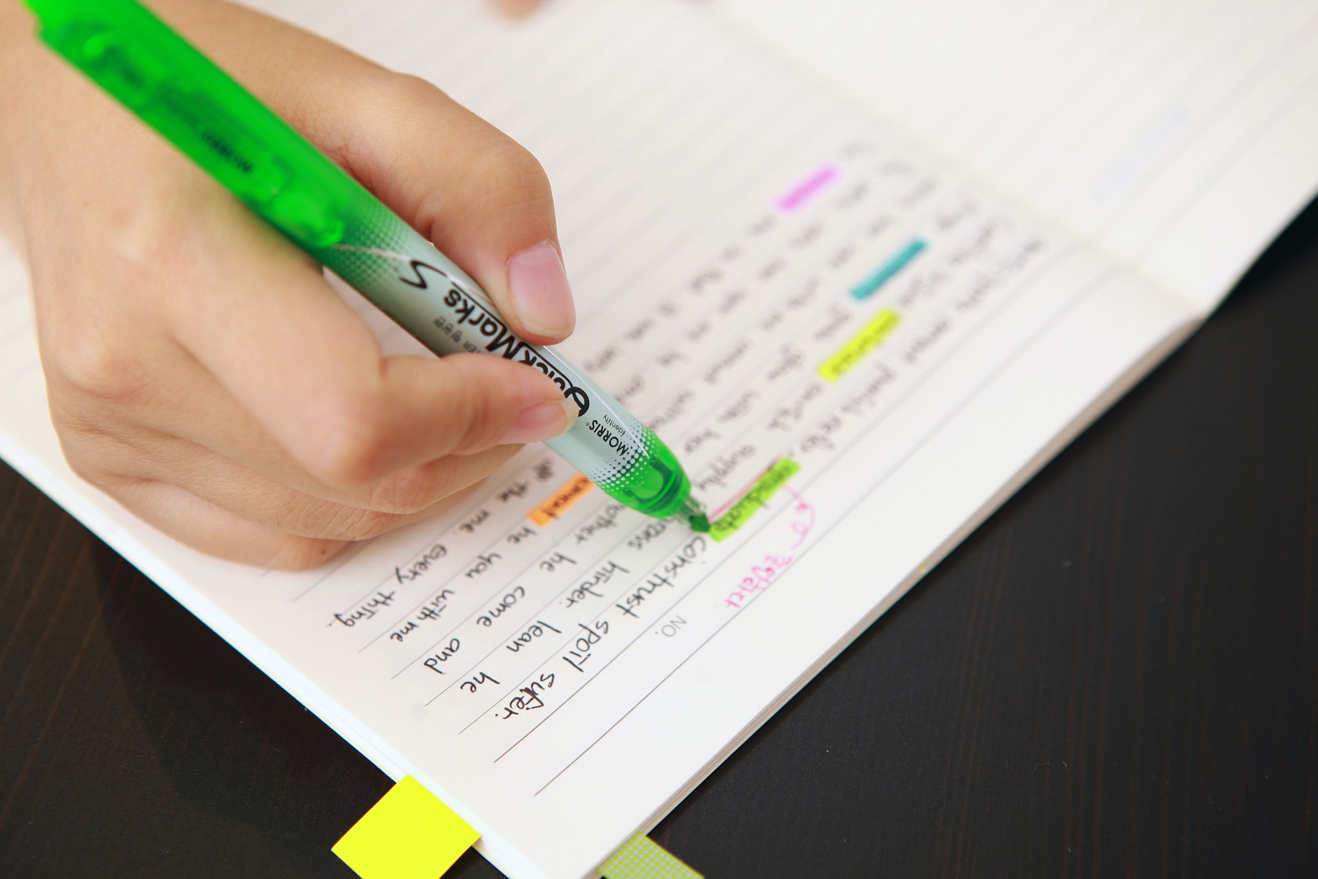 a hand highlighting text with a highligher pen